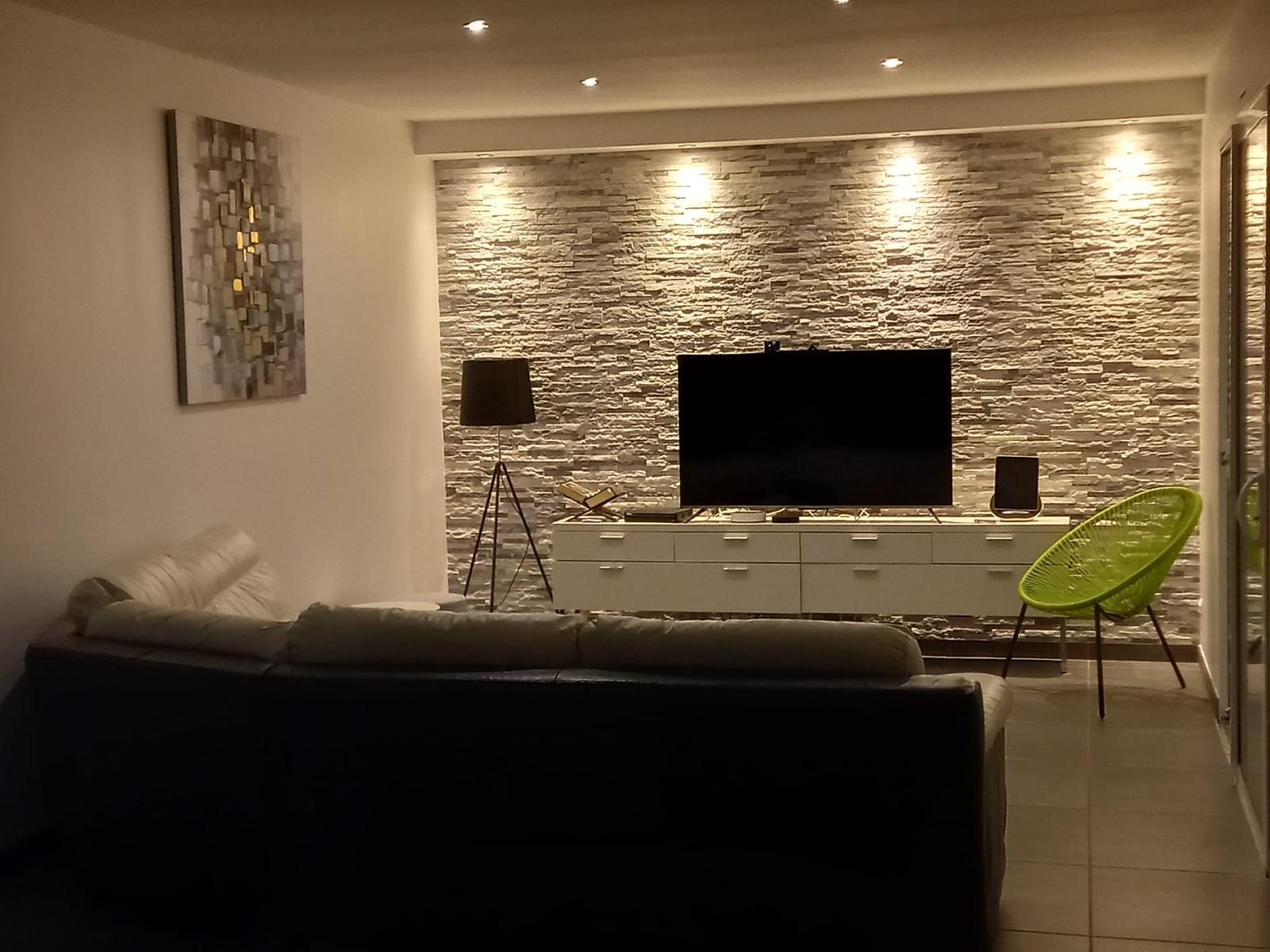Salon de Sweet Home, mur en pierre éclairé